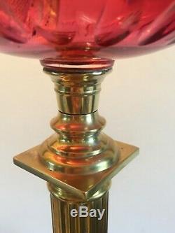 Late 19th century oil lamp with Cranberry Reservoir on a Corinthian brass column
